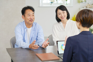 ビジネスウーマンと話す夫婦