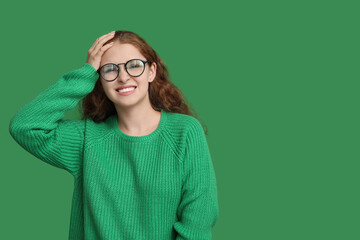 Portrait of ashamed young woman on green background