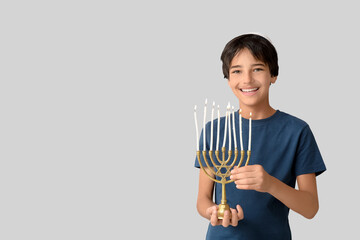 Fototapeta premium Little Israeli boy in kipa with menorah on grey background