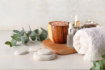 Spa composition with eucalyptus branches on light wooden table