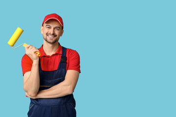 Portrait of male painter with paint roller on blue background