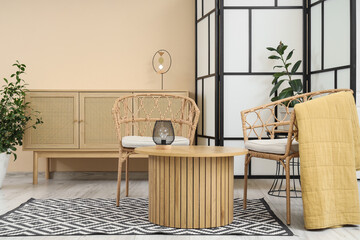 Interior of stylish living room with folding screen, drawers and armchairs
