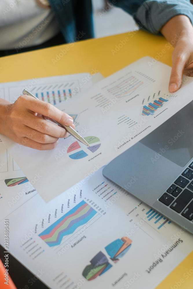 Poster close-up of hands reviewing financial charts and graphs, highlighting business analysis and data int