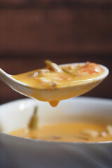 Close-Up of Creamy Soup in a Ladle with a Bowl in Background