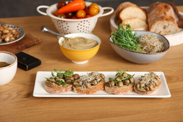 Plate with tasty vegan bruschettas on table in kitchen, closeup