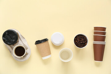Composition with disposable cups, holder and coffee beans on beige background