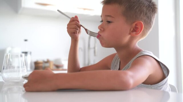Boy Eating an Omelette for Breakfast at Home in a Modern Kitchen
