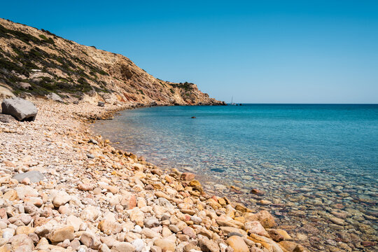 Beach with peebles at sunset, Milos island, Greece
