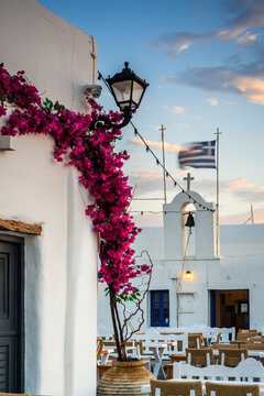 Square and church with greek flag in the old town, Naoussa, Paros island, Greece