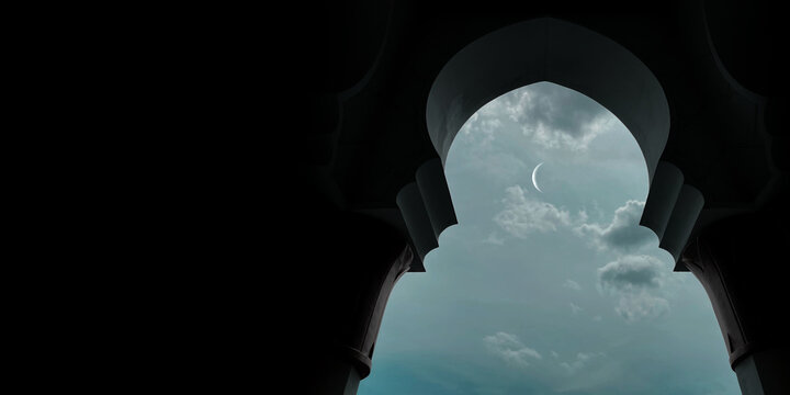 Ramadan concept - Ramadan kareem. The crescent moon in the sky is visible from inside the mosque door. Religious background image.