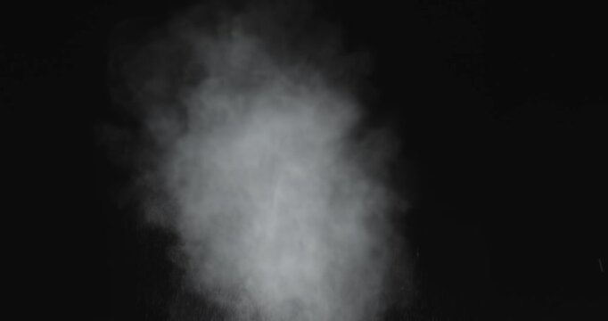 4K VFX practical element slow-motion close-up of dust explosion from bullet hitting the black wall. A dense powder explosion occurs against a black background action element. Gunshot impact on black