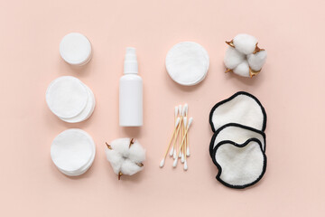 Composition with cosmetic products, pads, swabs and cotton flowers on color background