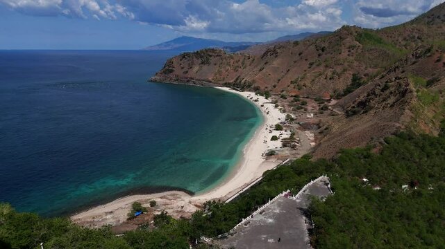 An aerial footage of Cristo Rey in East timor with sand beaches on the background