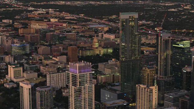 Aerial tracking shot of tall buildings in downtown Austin, vivid dusk in TX, USA