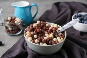 Bowl with healthy corn balls on grey grunge background, closeup