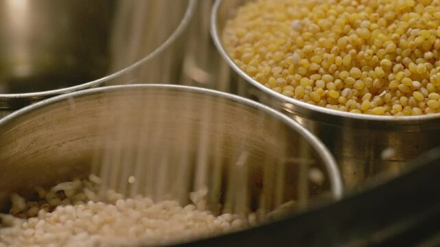 falling little millet in steel bowl with foxtail millet in the background for storage, 4k close up, stable shot
