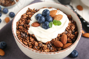 Chocolate tasty granola with nuts and berries on black background, closeup