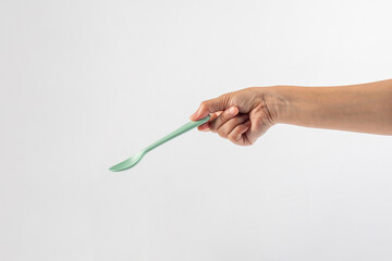 Green spoon and hand isolated on white background.