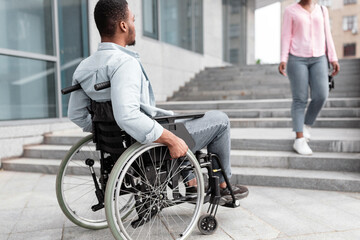 Handicapped people problems. African American disabled guy suffering from lack of wheelchair...