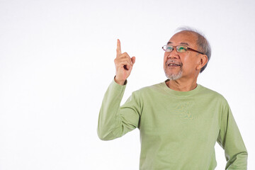 Naklejka premium Portrait Asian grey haired with glasses senior man point index fingers to space studio shot isolated on white background, elderly old man pointing finger up
