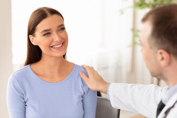 Senior Doctor Comforting His Patient During Medical Checkup In Clinic Office. Selective Focus
