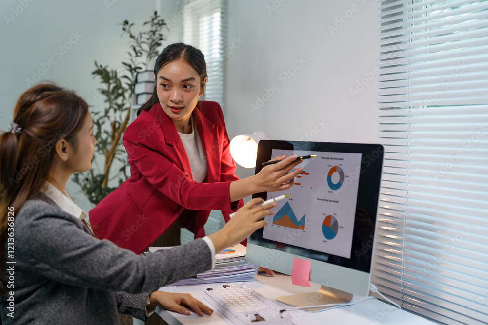 Poster two young businesswomen wearing suits are analyzing marketing data displayed on a computer screen. p