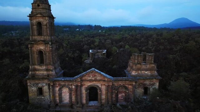 Twilight aerial of Old Church of San Juan Parangaricutiro and Paricutin&rsquo;s lava field