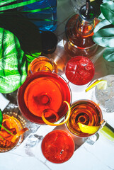 Summer alcoholic cocktail party with ready-made cocktails, bar tools and bottles of spirits on...
