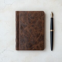 Brown leather notebook and fountain pen on a textured surface
