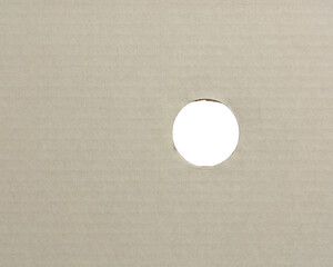 white corrugated cardboard box surface background with round hole or circle cut, ventilation hole in packaging