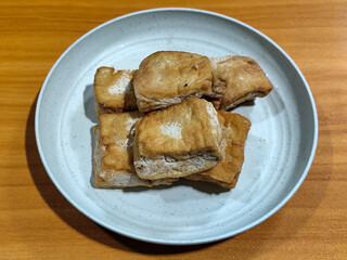 Fried tofu on a white plate. Traditional Indonesian snack.