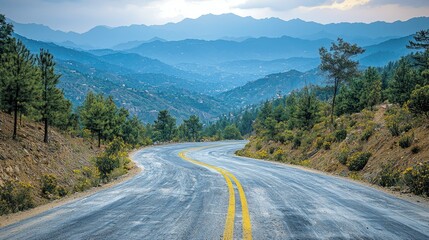 Naklejka premium Winding Mountain Road Through Blue Hues Landscape