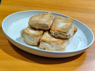 Fried tofu on a white plate. Traditional Indonesian snack.