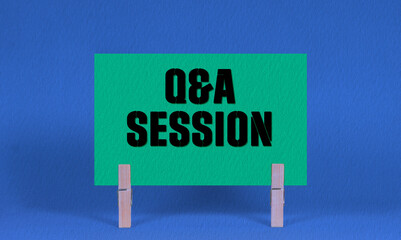 Q and A session Symbol. Concept words Q and A session on Green Rectangle Paper Held by Wooden Clothespin Blue Background. Business Q and A session Concept with Copy Space