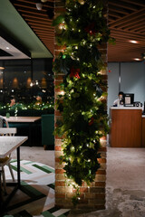 Christmas decoration details on a public vintage restaurant for holiday ambience with hanging lamp and table set