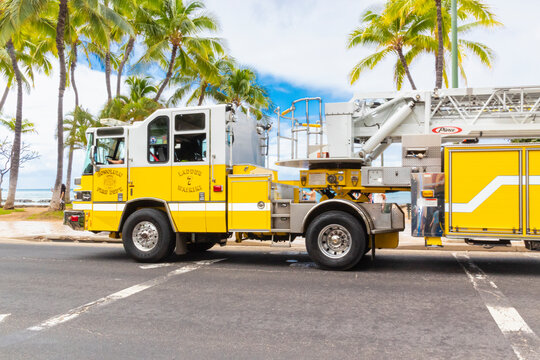 Honolulu, Hawaii, USA - February 22, 2024 - A bright yellow Honolulu Fire Department vehicle traveling along Waikiki Waterfront, providing fire protection and emergency medical services.