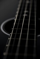 Fototapeta premium Dark Acoustic Guitar: Strings and Soundhole in Dramatic Close-up