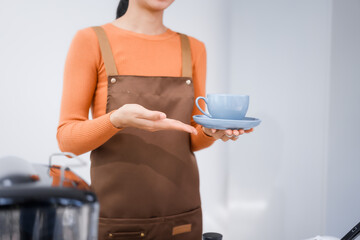 Asian female barista with a beautiful smile, skillfully making coffee in a cozy small shop, creating a warm and welcoming atmosphere for customers in the charming cafe