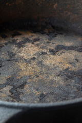 Close up of an old rusty cast iron frying pan background. Vintage cooking utensil concept