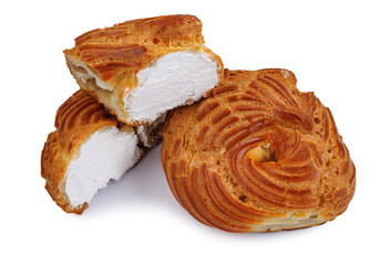 Cut and whole profiterole cake isolated on white background. Eclair with white filling.