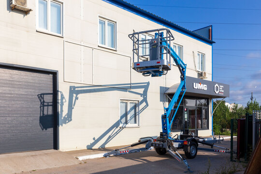 Russia. Samara, August 22, 2024: a new articulated boom lift on a trading platform near a store on a sunny summer day. Text in Russian: gidroremservis