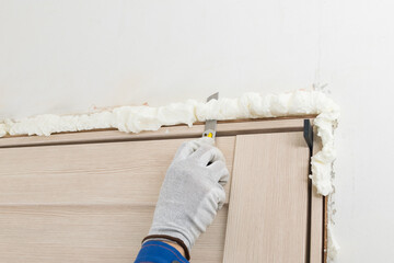 installation of interior door frame, close-up, knife cuts mounting foam