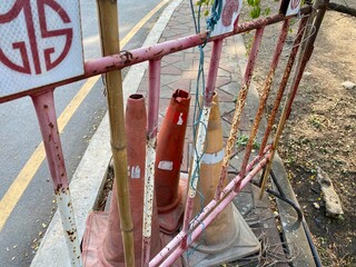 Fototapeta premium Close-up of construction barrier with warning cones near bike path in Lumphini Park, Bangkok, emphasizing park safety and maintenance.