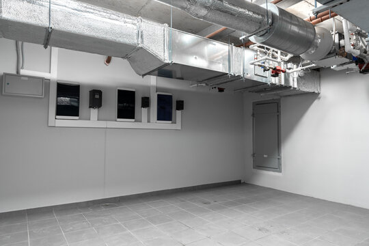 Industrial basement room with ventilation system and empty floor space in an urban setting