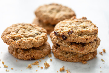 Close view of oatmeal cranberry cookies in stacks on white countertop