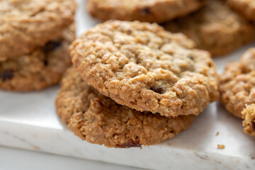 Closeup view of a small stack of oatmeal cranberry cookies on marble tabletop