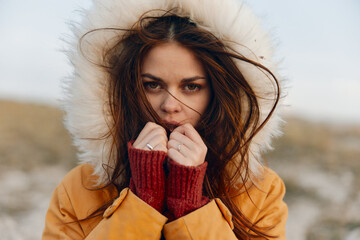 Woman in winter coat contemplating the snowy field in quiet reflection and beauty