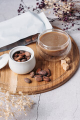cocoa beans on a wooden background, transparent cup with fresh cocoa, packaging mockup