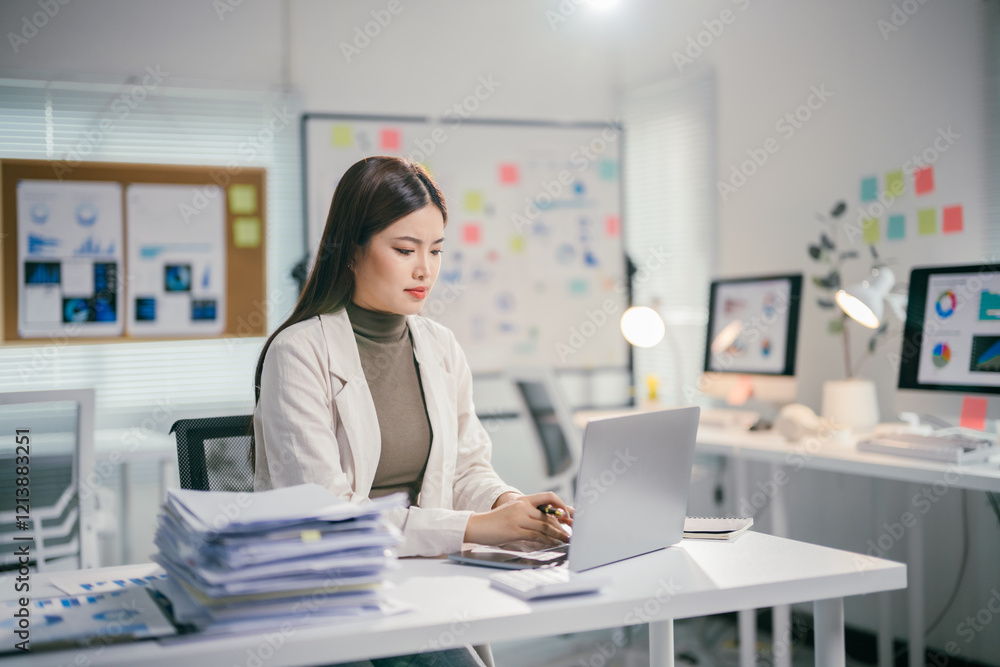 Poster young professional woman analyzing data and working on a computer in a modern office