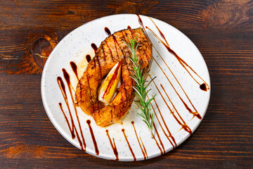 Grilled chicken breast garnished with rosemary and sauce on white plate Savory vegetable pie served with fresh garnishes on a white plate